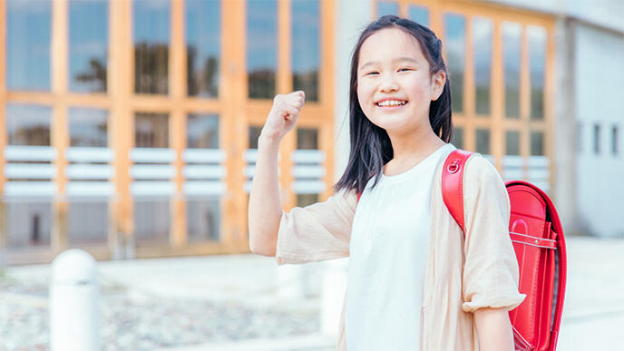 ガッツポーズをする小学生の女の子の写真